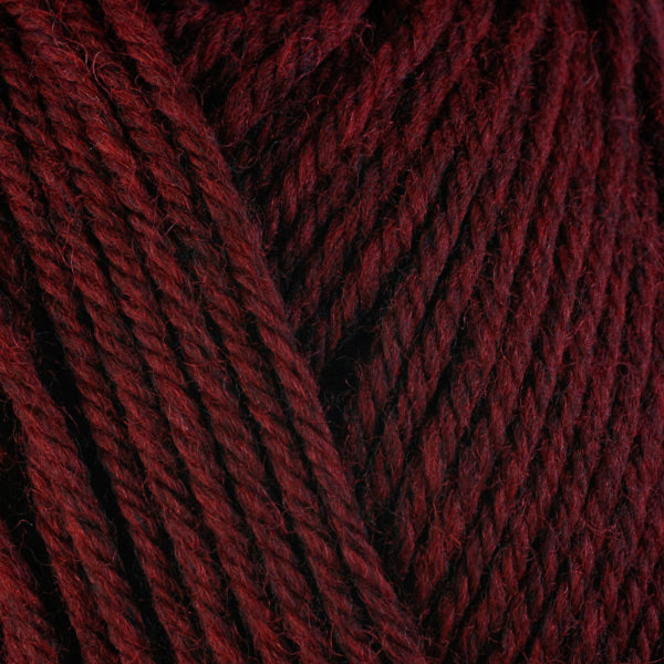 A close-up image of a skein of Berroco Ultra Wool bulky weight yarn in a heathered dark red color.