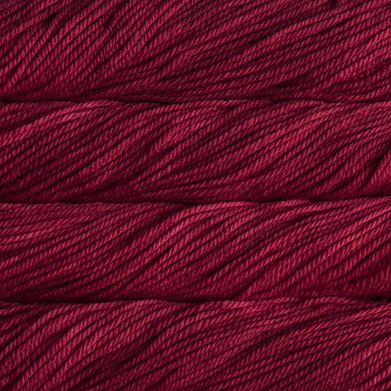 A close up image of skeins of Malabrigo Chunky bulky weight yarn in deep red shades.