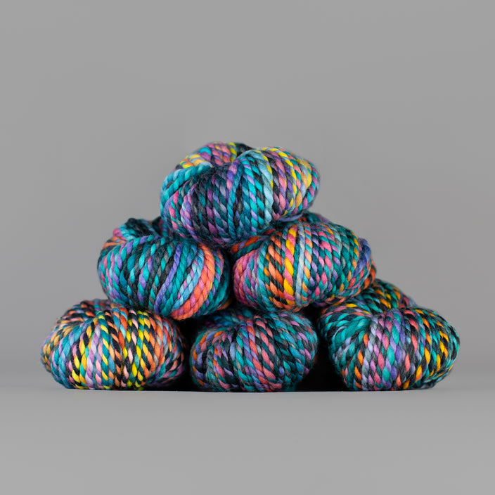Skeins of Spincycle Plump Bulky weight yarn in blue, pink, yellow, and purple color gradient