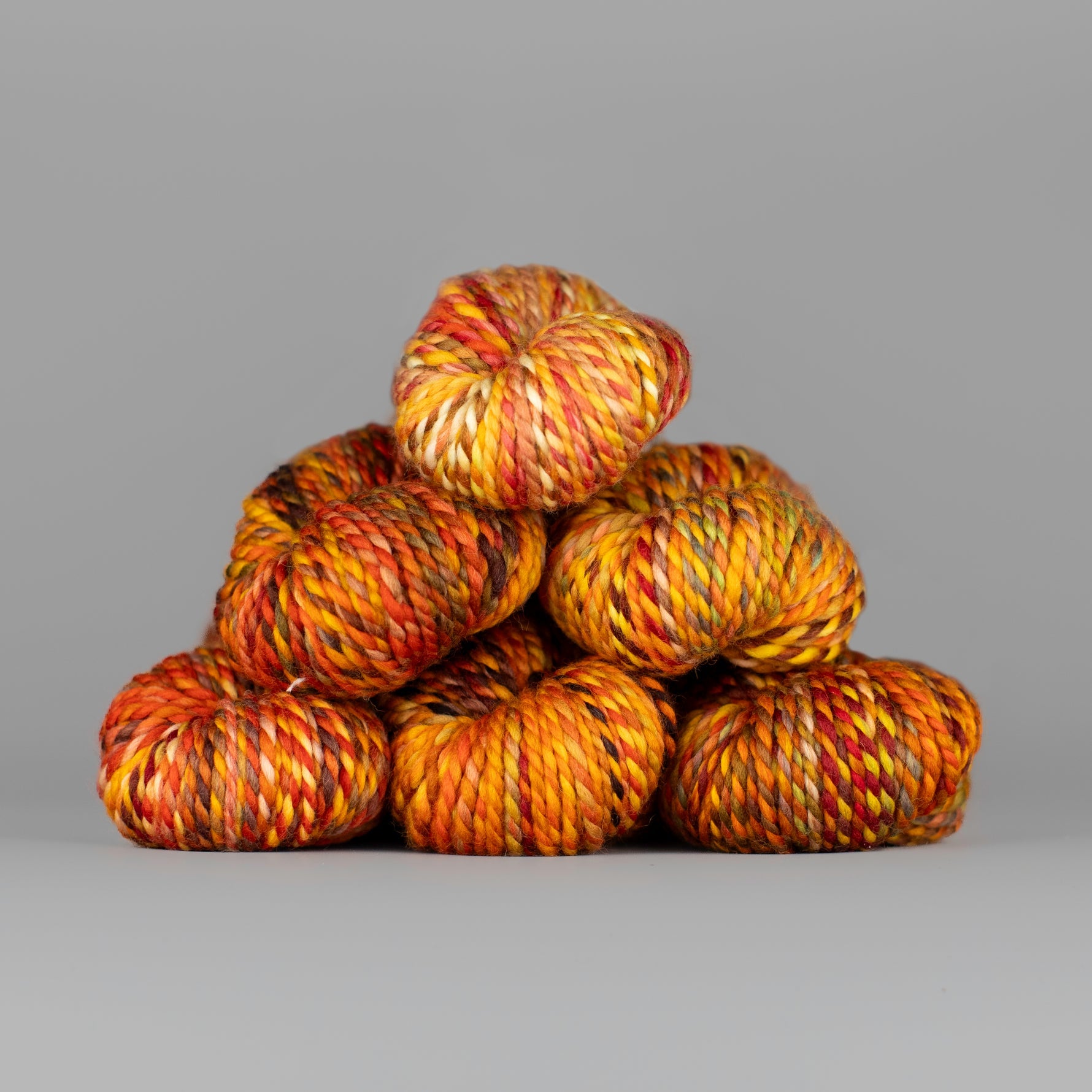 Skeins of Spincycle Plump Bulky weight yarn in red, orange, yellow, and brown color gradient