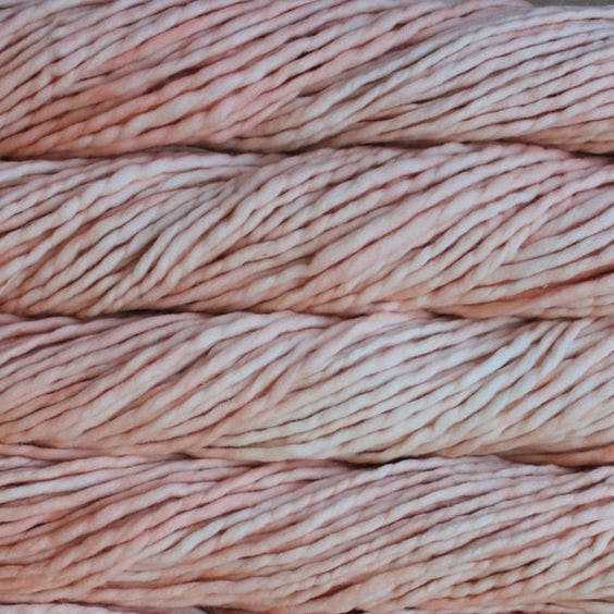 A close-up image of skeins of Malabrigo Rasta yarn in pale pink and cream shades, displaying the texture and color variation.