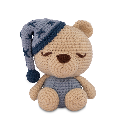 Crocheted teddy bear with a blue pajama hat and outfit on a white background