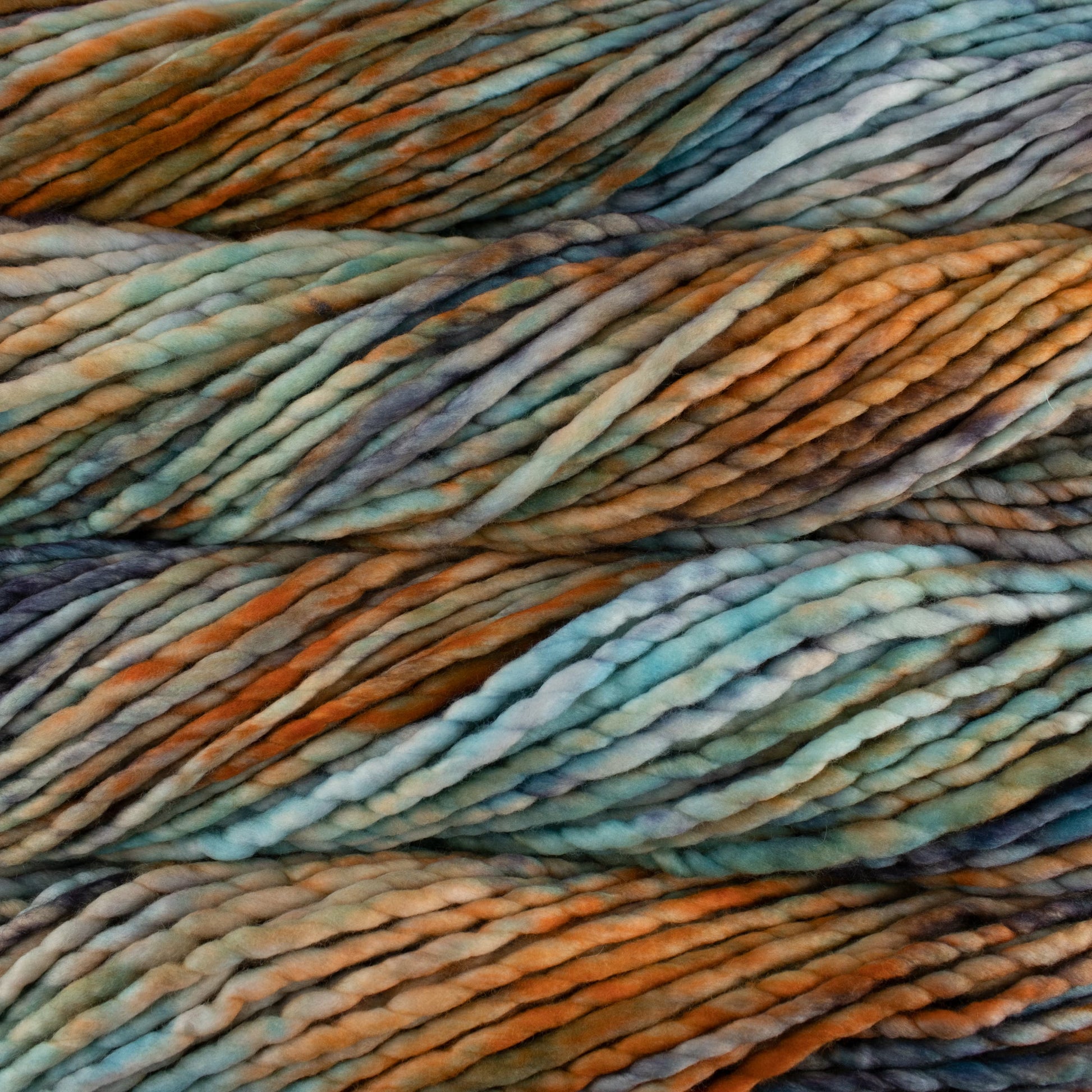 Close-up of multicolored yarn with shades of light blue, rust orange, and water green.