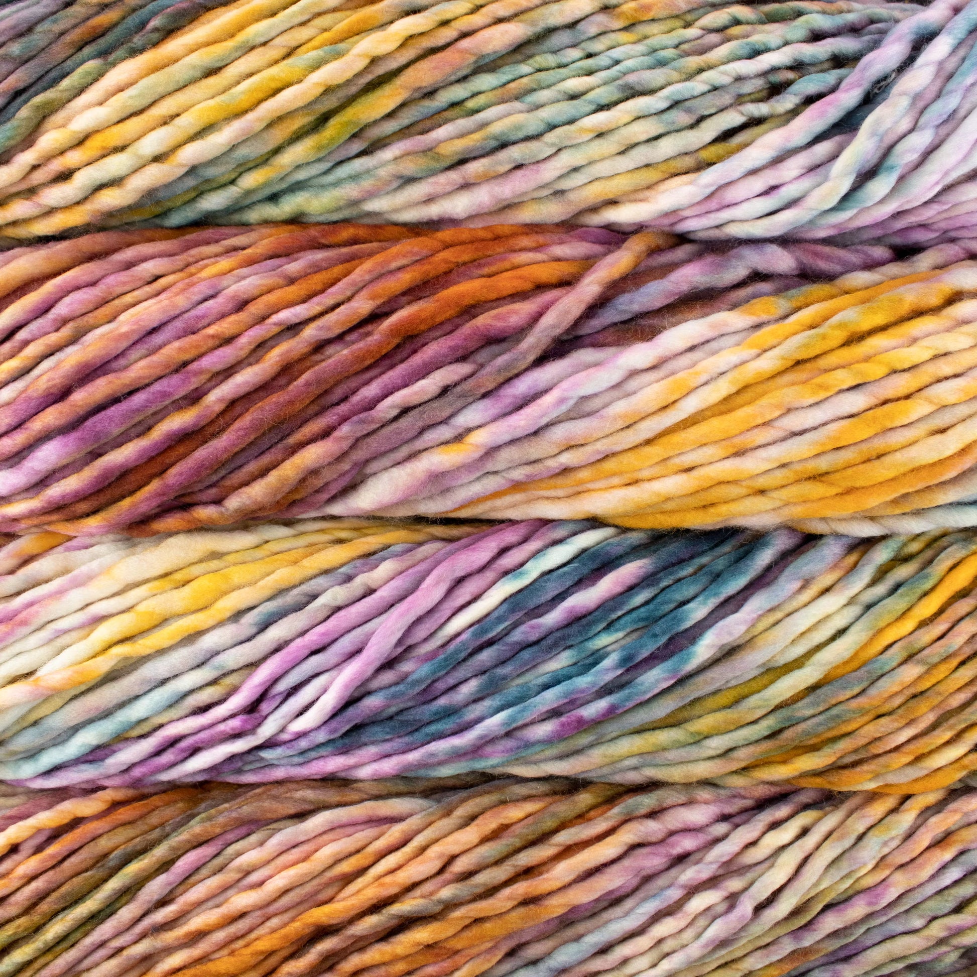 A close-up image of skeins of Malabrigo Rasta yarn in yellow, orange, purple, teal and white colors, displaying the texture and color variation.