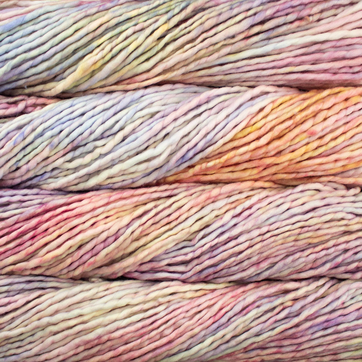 A close-up image of skeins of Malabrigo Rasta yarn in a rainbow of pastel colors, displaying the texture and color variation.
