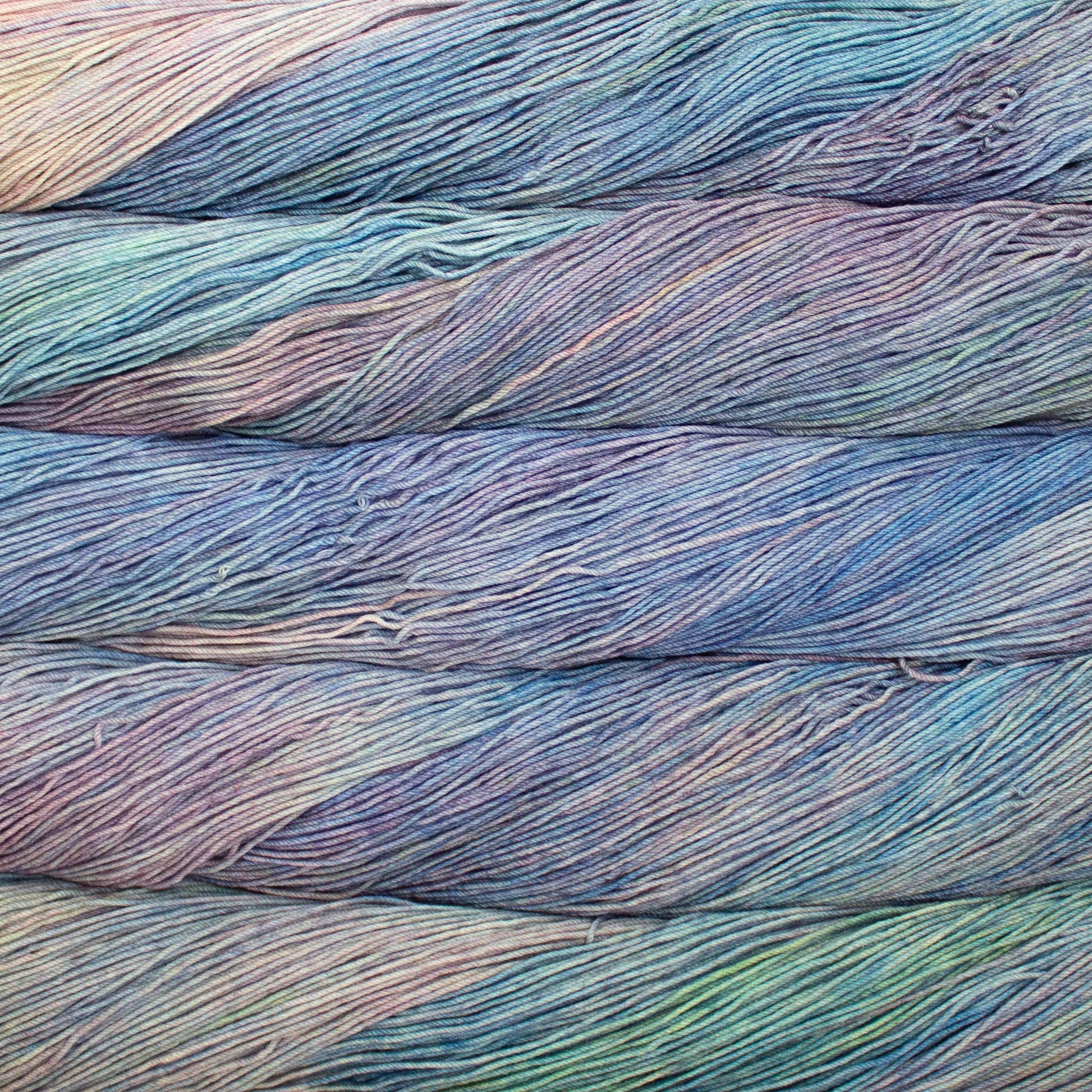 Close-up of multicolored yarn strands in light blue, light green, and light pink