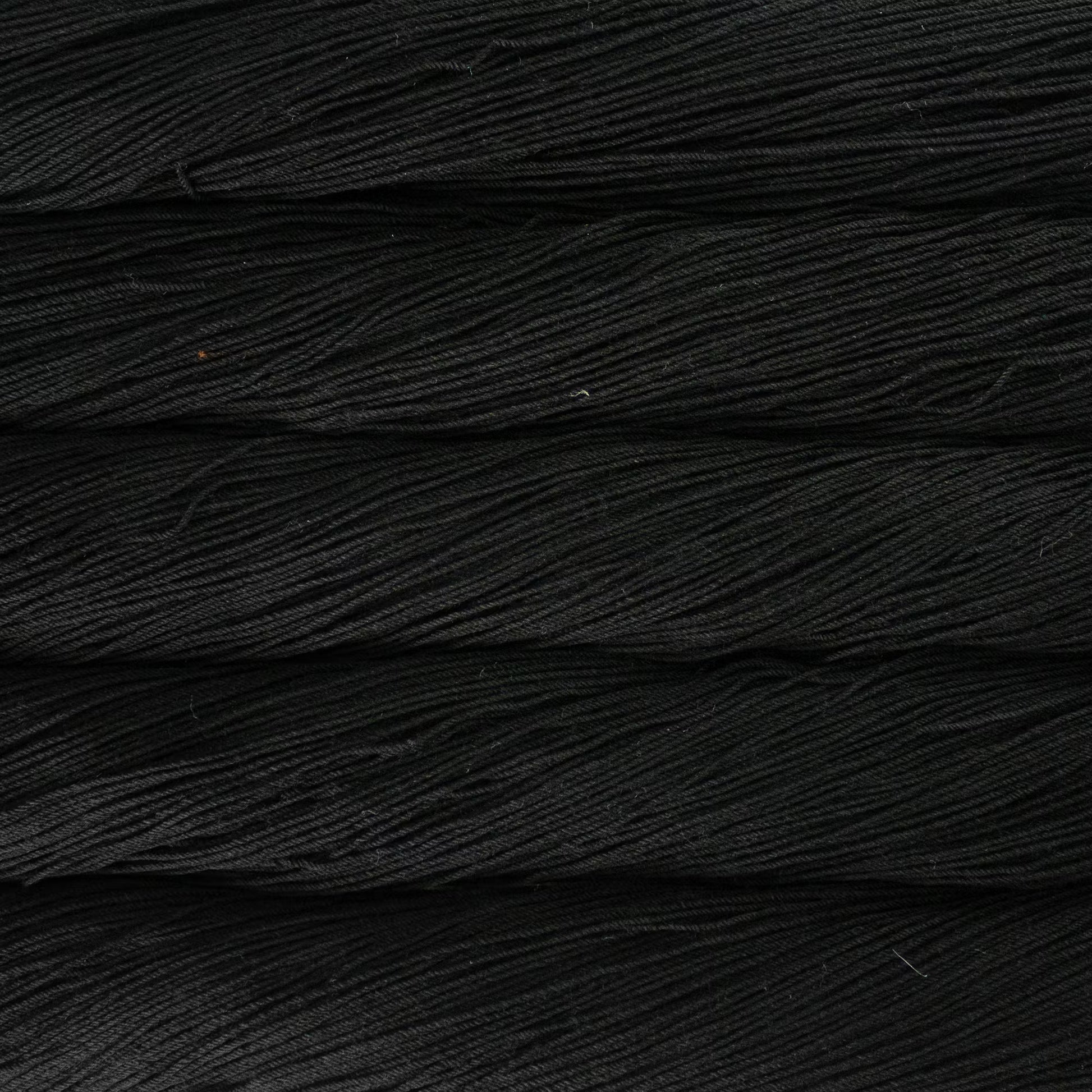 A close up of a skein of Malabrigo Ultimate Sock fingering weight yarn in black color