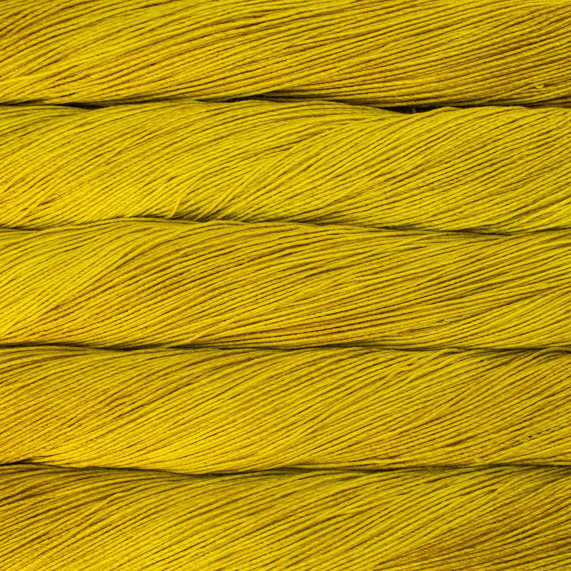 Close up of several skeins of bright golden yellow yarn