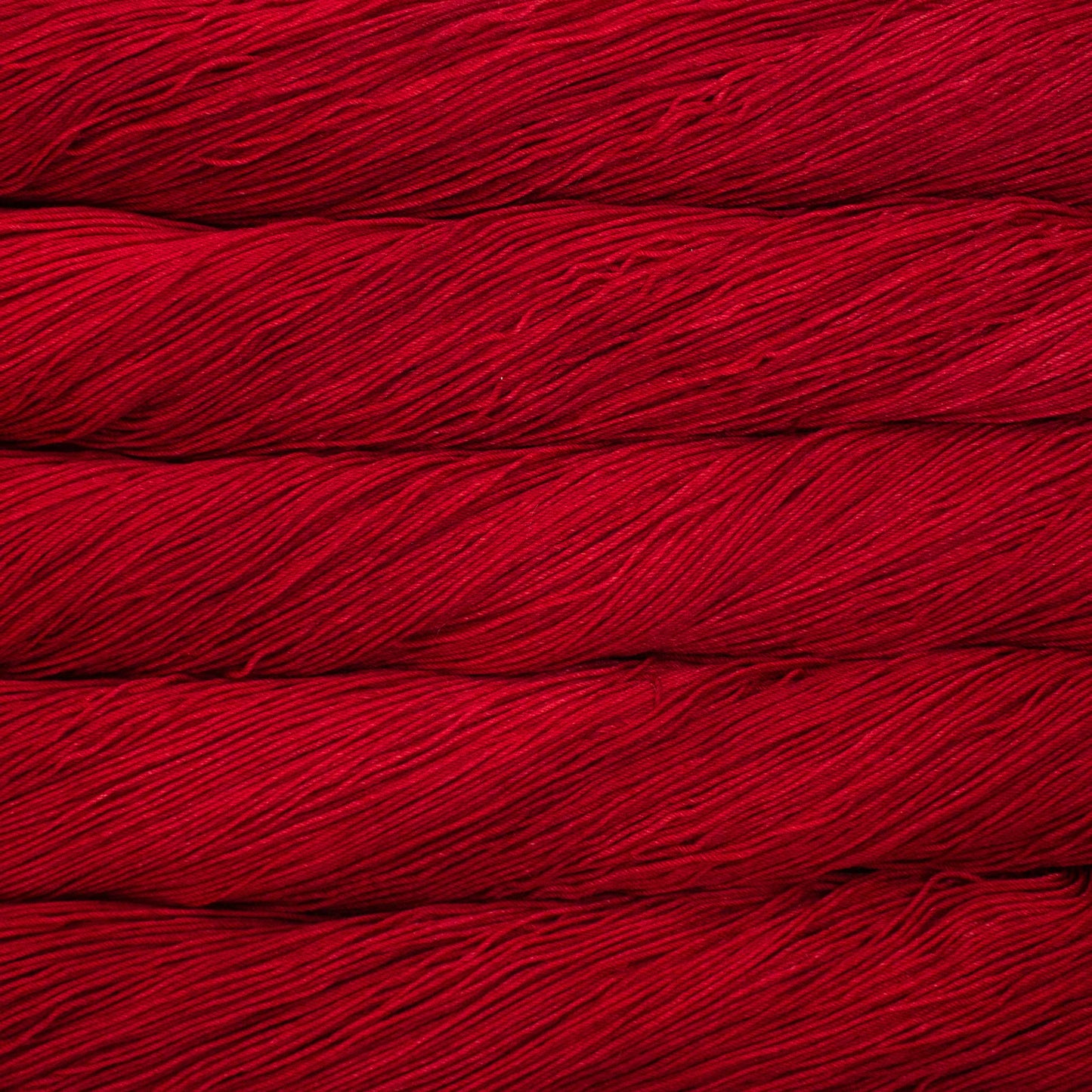 A close up of a skein of Malabrigo Ultimate Sock fingering weight yarn in vibrant red color