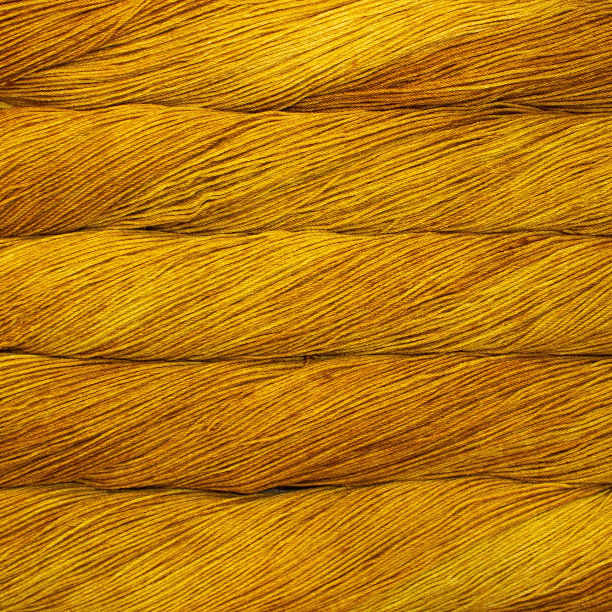 close up of various skeins of yarn in bright orange yellow