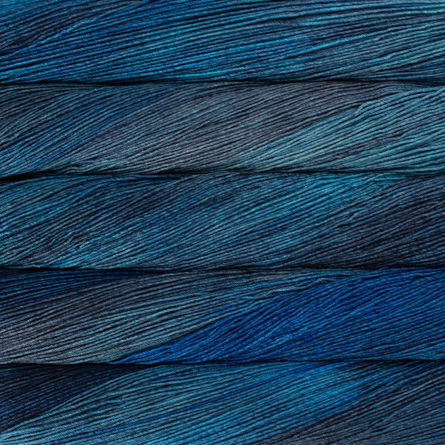 A close up of a skein of Malabrigo Ultimate Sock fingering weight yarn in light and dark blue grey colors