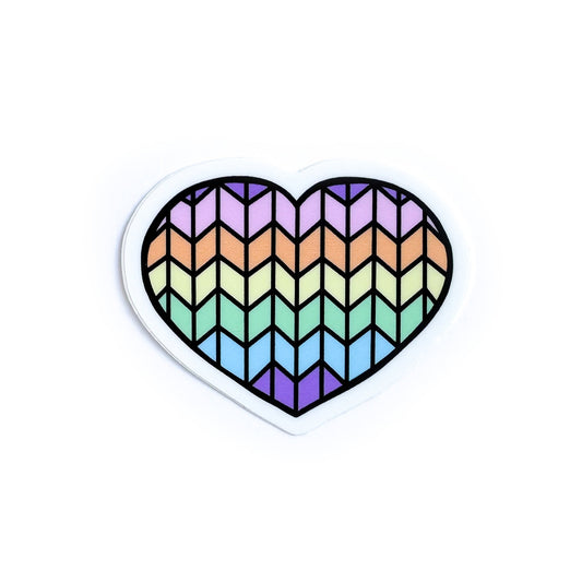 A heart shaped vinyl sticker with a pastel rainbow stockinette stitch pattern on it. 