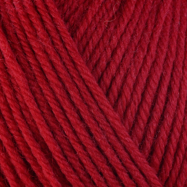 A close-up image of a skein of Berroco Ultra Wool worsted weight yarn in a solid bright red color.