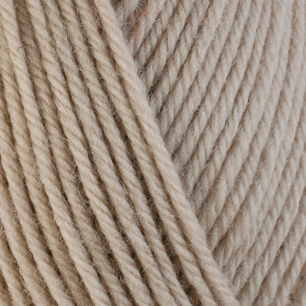 A close-up image of a skein of Berroco Ultra Wool worsted weight yarn in a solid beige color.
