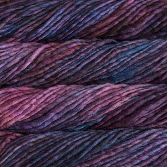 A close-up image of a skein of Malabrigo Rasta yarn in shades of purple and blue, displaying the texture and color variation.