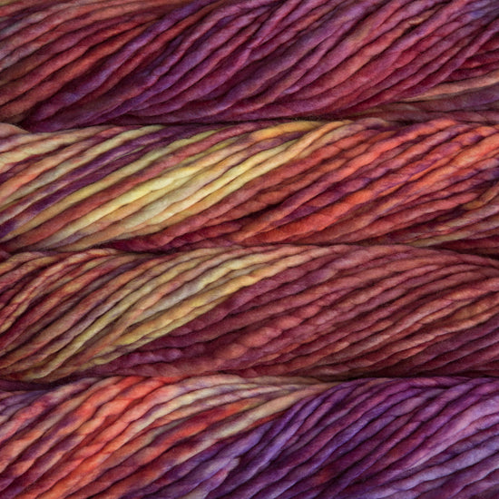 A close-up image of skeins of Malabrigo Rasta yarn in shades of red, purple, and yellow, displaying the texture and color variation.