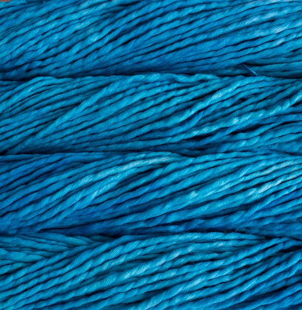 A close-up image of skeins of Malabrigo Rasta yarn in bright blue, displaying the texture and color variation.
