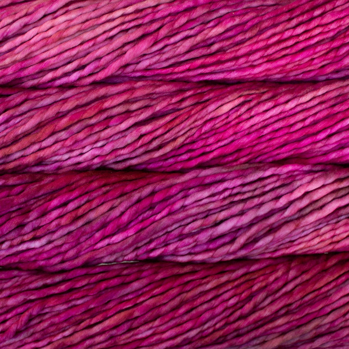 A close-up image of skeins of Malabrigo Rasta yarn in shades of pink, displaying the texture and color variation.