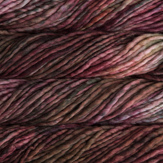 A close-up image of skeins of Malabrigo Rasta yarn in shades of brown, red, and pink, displaying the texture and color variation.