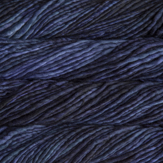 A close-up image of skeins of Malabrigo Rasta yarn in dark blue and purple shades, displaying the texture and color variation.