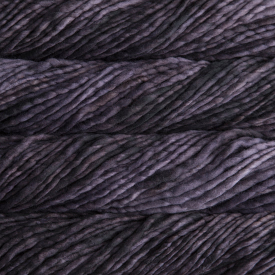 A close-up image of skeins of Malabrigo Rasta yarn in gray and violet shades, displaying the texture and color variation.