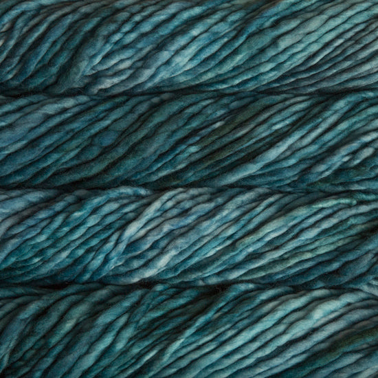 A close-up image of skeins of Malabrigo Rasta yarn in teal shades, displaying the texture and color variation.