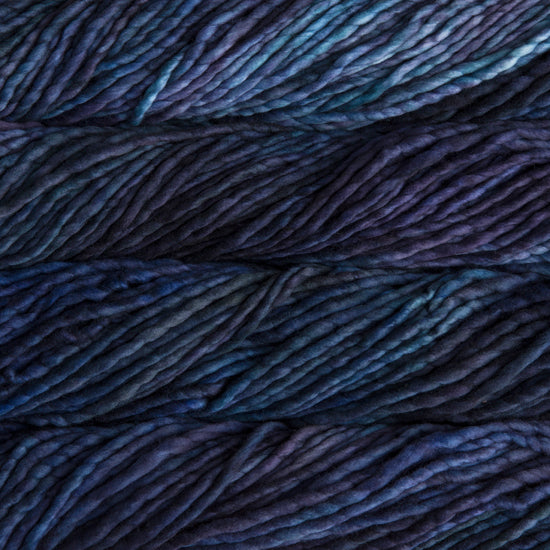 A close-up image of skeins of Malabrigo Rasta yarn in dark purple, navy, and light blue, displaying the texture and color variation.