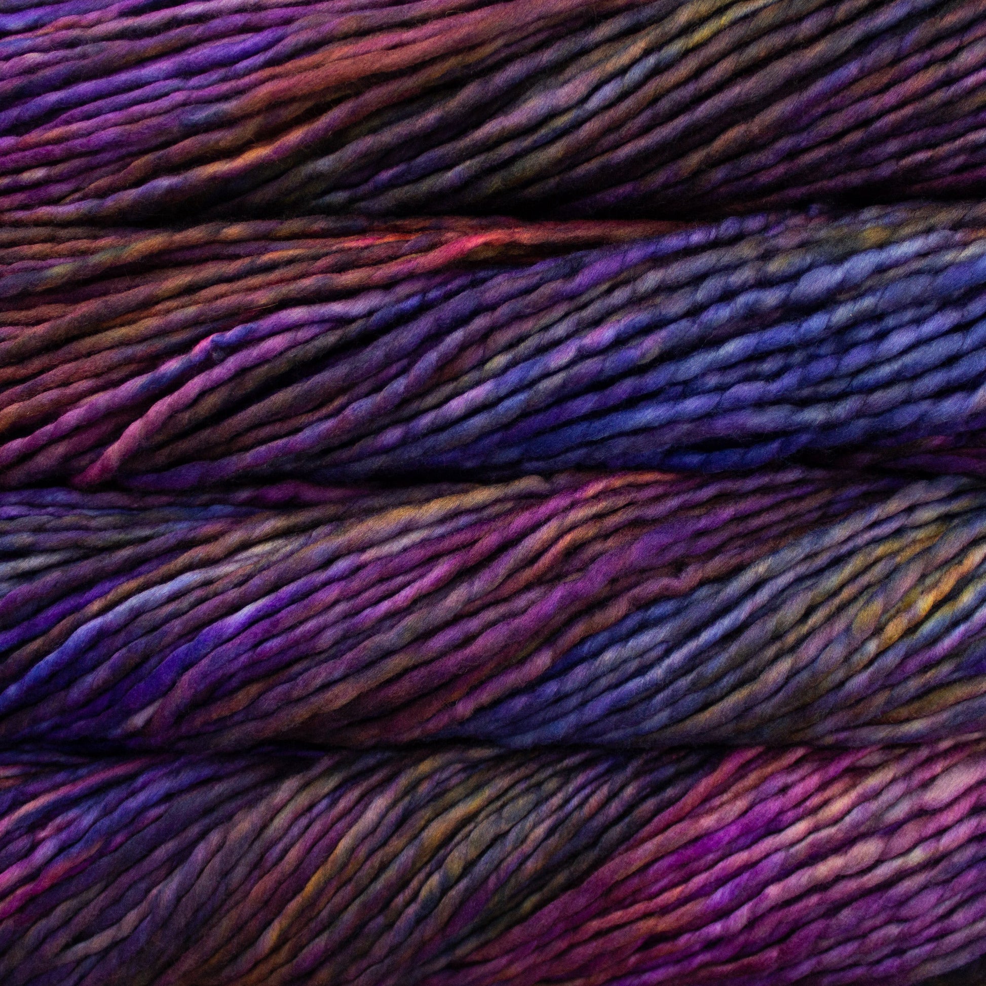 A close-up image of skeins of Malabrigo Rasta yarn in shades of pink, purple, and orange, displaying the texture and color variation.