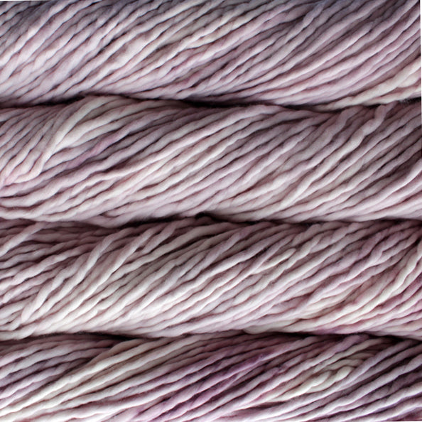 A close-up image of skeins of Malabrigo Rasta yarn in shades of soft pink, displaying the texture and color variation.