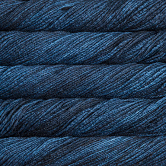 A close up of skeins of Malabrigo Rios worsted weight yarn in dark blue color