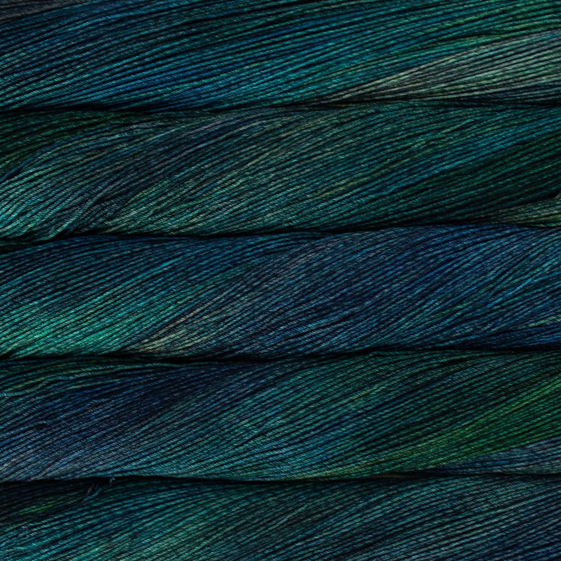 Close up of several skeins of yarn in blue green cplors